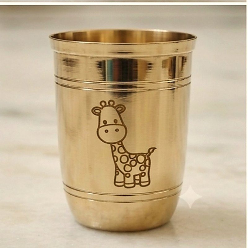 Close-up of the giraffe engraved on the side of the ribbed bronze tumbler