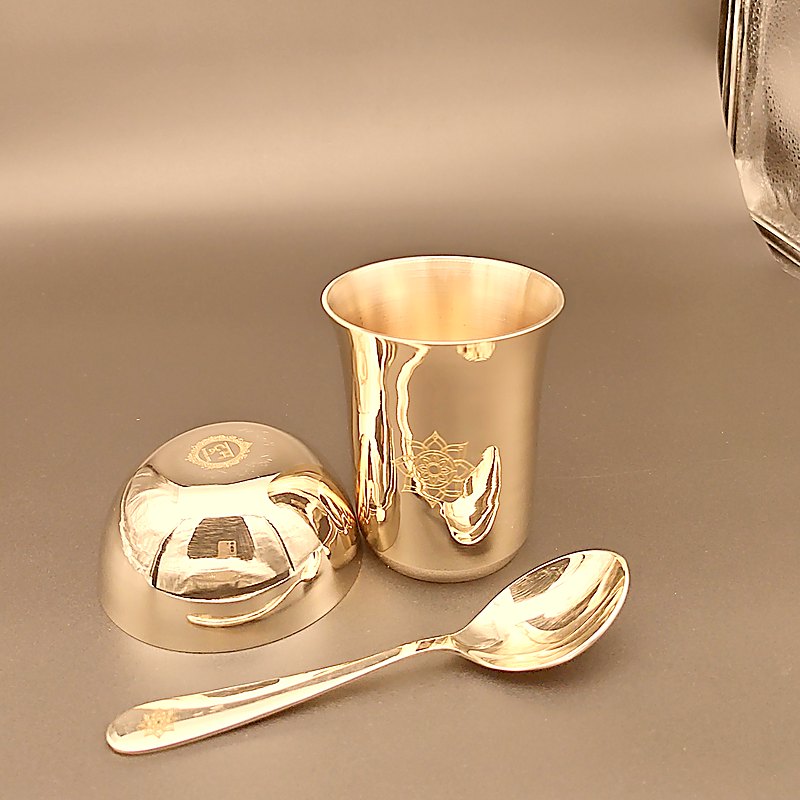 The tumbler, an upturned katori and the spoon, each carrying the same rosette