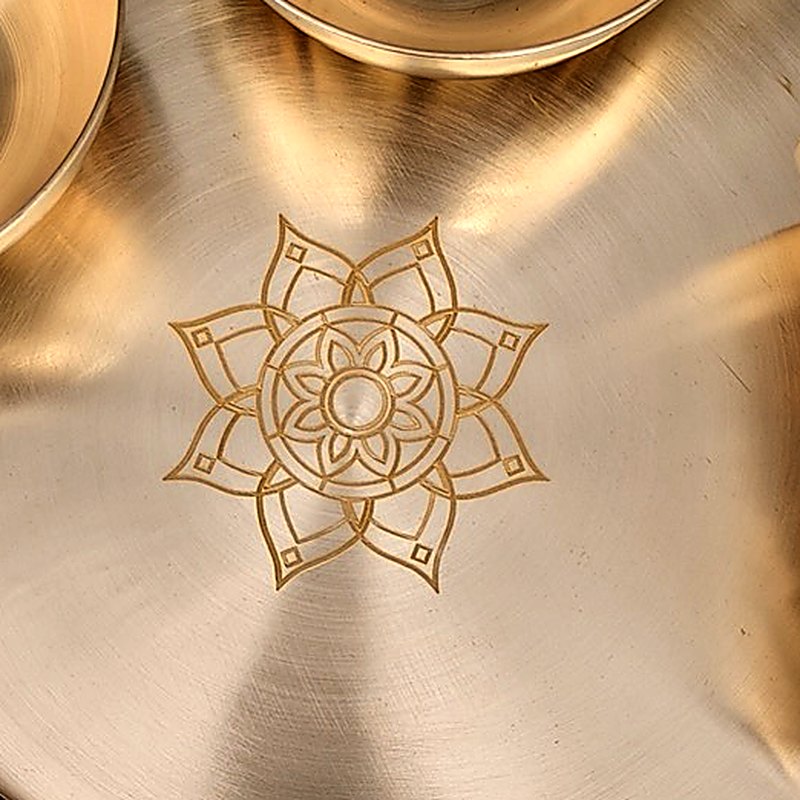 Close-up of the lotus rosette laser-engraved into the centre of the bronze thali