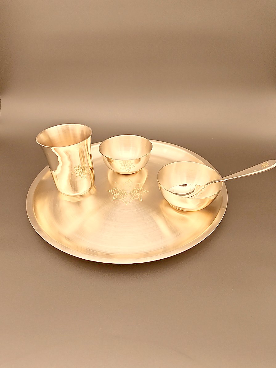 Tuoom kansa dinner set — bronze thali, two katoris, tumbler and spoon, seen at an angle