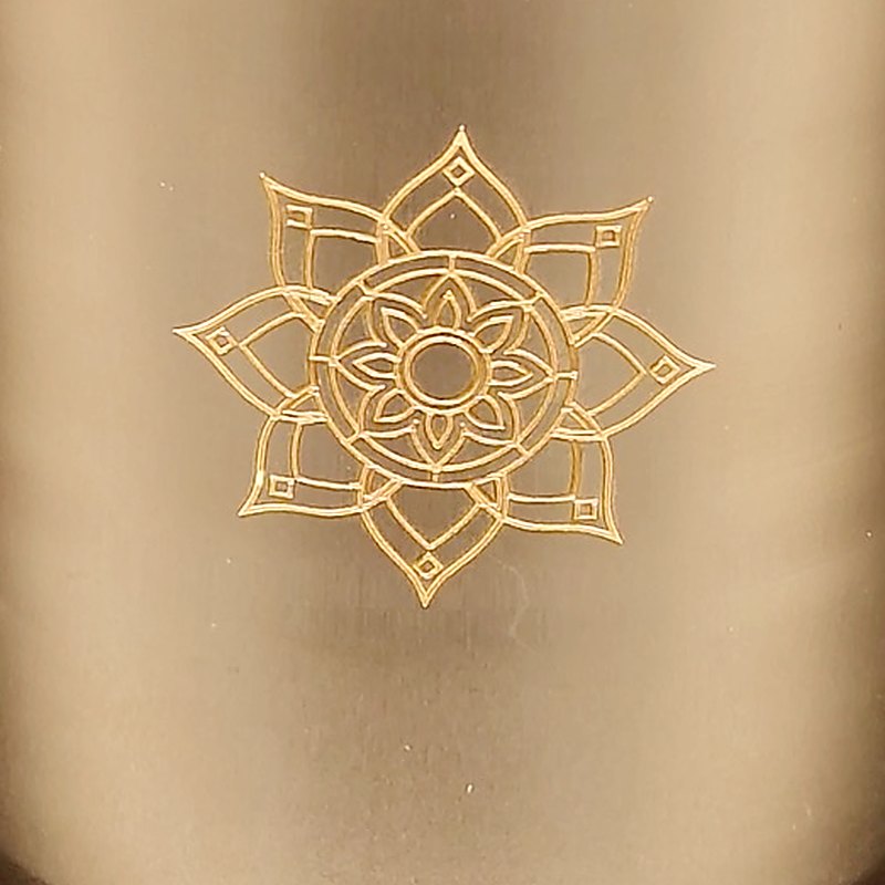 Close-up of the lotus rosette laser-engraved into the side of the bronze tumbler
