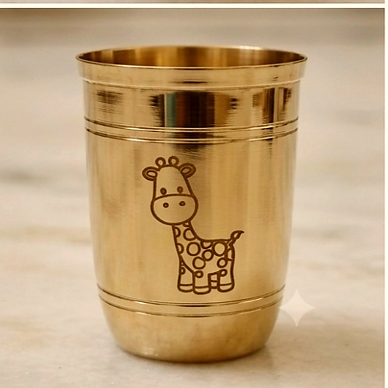 Close-up of the giraffe engraved on the side of the ribbed bronze tumbler